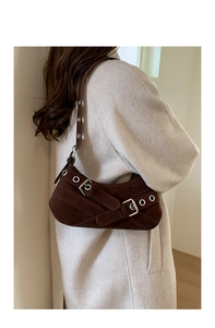 Detail of vintage brown suede shoulder bag featuring silver buckles and metal eyelets