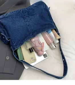 Detail showing the large interior capacity of this navy denim tote bag with daily items
