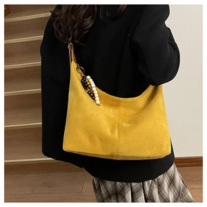 Détail du grand sac cabas en daim jaune avec breloque ethnique en perles sur la fermeture