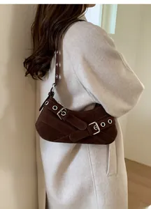 Detail view of dark brown vintage shoulder bag with silver eyelets and buckle accents