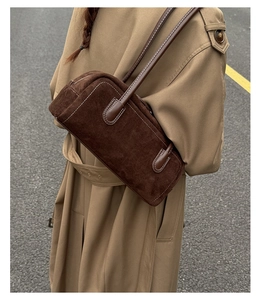 Detail of dark brown suede Boston bag showing contrast stitching and premium leather strap
