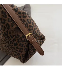 Detail der Totebag mit Leopardenmuster, goldener Metallschnalle und braunem Lederband