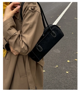 Retro black suede Boston shoulder bag with contrast stitching in an autumn street setting