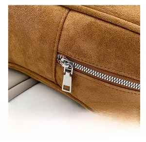 Macro view of smooth silver metal zipper on brown suede tote bag with fine texture