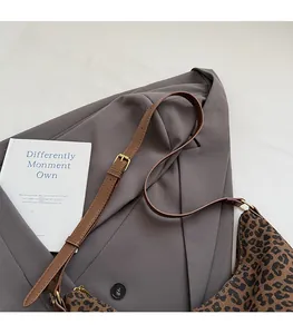 Detailaufnahme der Schultertasche mit Leopardenmuster, Lederriemen und Goldreißverschluss