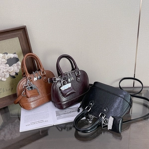 Sacs à main chic en forme de coquillage en marron, rouge et noir avec cadenas déco