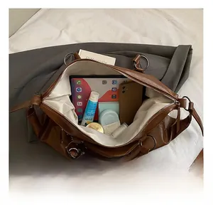 Interior view showing the large capacity of the brown leather tote with various daily essentials