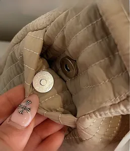Vista macro dettagliata della chiusura magnetica argento sulla borsa hobo trapuntata