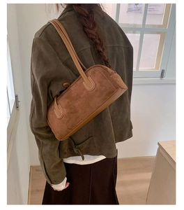 Detail of vintage brown suede Boston bag with white stitching shown on shoulder