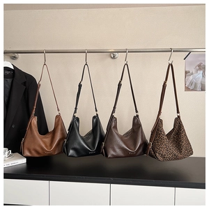 Hobo-Halbmondtaschen mit Leopardenmuster und Unifarben an einer Kleiderstange