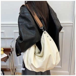 Detail of cream canvas tote bag with brown wide strap and silver metal hardware