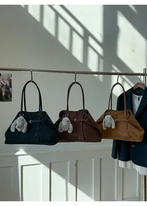 Three suede tote bags in black, dark brown, and caramel with plush rabbit charm detail