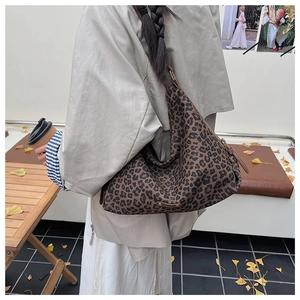 Detail einer großen Hobo-Tasche mit Leopardenmuster und verstellbarem Gurt im Freien