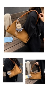 Detalle del bolso tote de ante marrón con correa de cuero y colgante de oso al aire libre