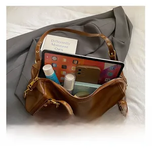 Top view showing the spacious interior of a brown tote bag holding a tablet and essentials