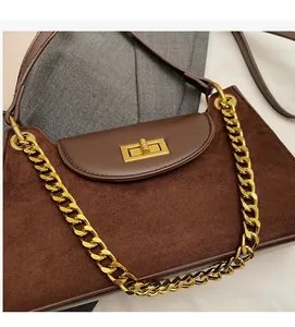 Nahaufnahme der braunen Wildledertasche mit goldener Kette und glatter Lederklappe