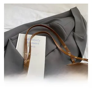 Detail of vintage brown oil leather tote with adjustable gold buckle and eyelets