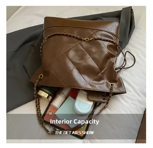 Detailed interior of brown quilted tote bag showing large capacity for tablet and phone