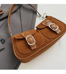 Detail der Wildleder-Baguette-Tasche mit zwei Klappentaschen und Silberschnallen