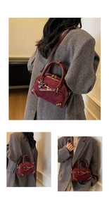 Detail of vintage burgundy Boston bag with gold hardware and suede leather texture