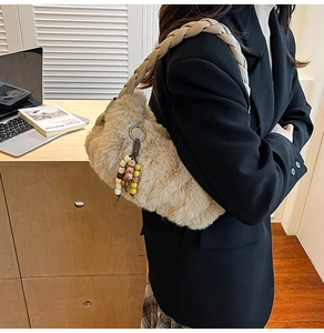 Détail du sac à bandoulière en peluche beige avec anse tressée et pendentif à perles