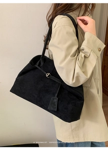 Detail showing high-capacity black suede tote bag texture with elegant metallic D-ring buckle