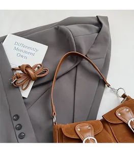 Detailansicht der braunen Wildleder-Baguette-Tasche mit Metallschnalle und Riemen