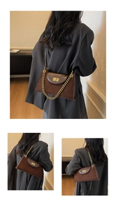 Details der dunkelbraunen Leder-Baguette-Tasche mit Wildleder-Nähten und goldenem Drehverschluss