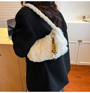 Détail du sac à bandoulière en fausse fourrure blanche avec sangle tressée et charm perlé