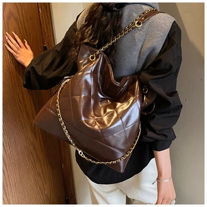 Close-up of brown quilted leather tote bag with elegant chain strap and vintage style