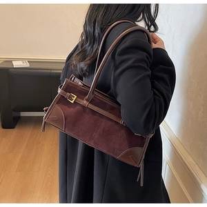 Detail of vintage brown suede tote bag featuring slim shoulder straps and metal buckle