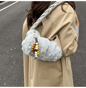 Detail of grey plush cloud bag with braided strap and colorful wooden bead charm