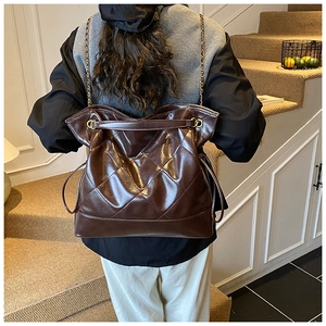 Detailed view of the dark brown quilted leather tote bag worn on the shoulder