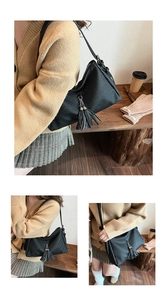Detailaufnahme der schwarzen Falten-Tasche mit silbernem Kettenanhänger und PU-Leder-Struktur