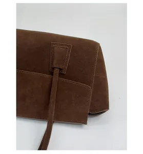 Detailed macro view of the premium dark brown faux suede fabric and stitching on tote bag