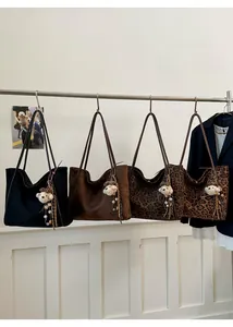 Detail of vintage tote bags in black, brown, and leopard print with bear charms