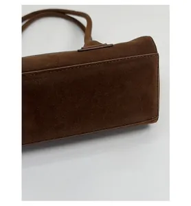 Detail view of the wide bottom and stitching of this brown suede large hobo shoulder bag
