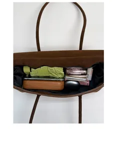 Vertical top view showing large capacity of brown suede tote bag with daily essentials