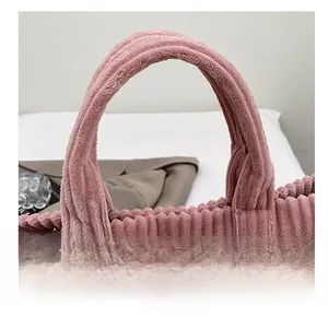 Detailed close-up of thick pink corduroy tote bag handle with refined stitching