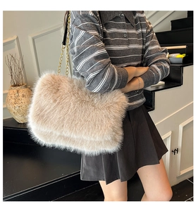 Dettaglio della borsa a spalla in ecopelliccia beige con catena dorata su modella