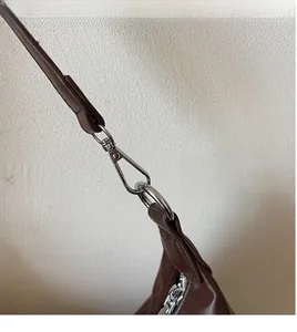 Détail du sac bandoulière marron avec crochet métallique argenté robuste et sangle