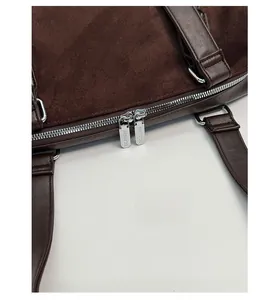 Detail of dark brown suede tote bag featuring silver-tone double metal zippers and stitching
