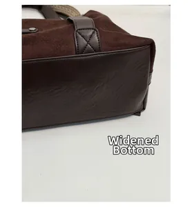 Detail view of the widened bottom design on a dark brown suede tote bag for stability