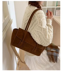 Detailed view of the dark brown suede hobo bag with a minimalist rectangular flip-top design