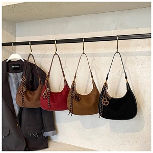 Detail of four suede hobo bags in assorted colors with unique woven cord decorations
