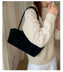 Détail du sac cabas en daim noir de haute qualité porté avec une tenue minimaliste
