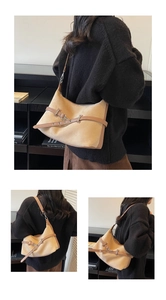 Détail du sac à bandoulière en daim camel avec ceinture en cuir élégante et boucle métallique