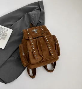 Close-up of vintage brown suede backpack featuring metallic rivets and cross hardware details