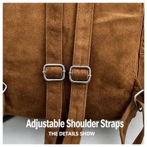 Detail of adjustable double straps on a brown suede tote bag with silver metal buckles