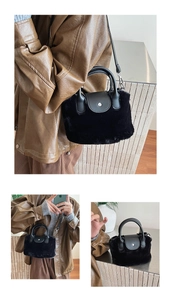 Detail of black faux fur handbag with leather flap and round handle in a lifestyle setting